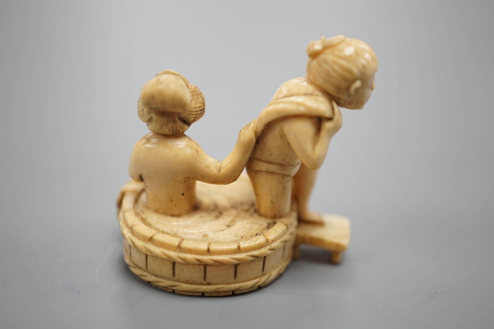 A Japanese ivory Netsuke of a bathing couple, Meiji period, 3.5 cms high.